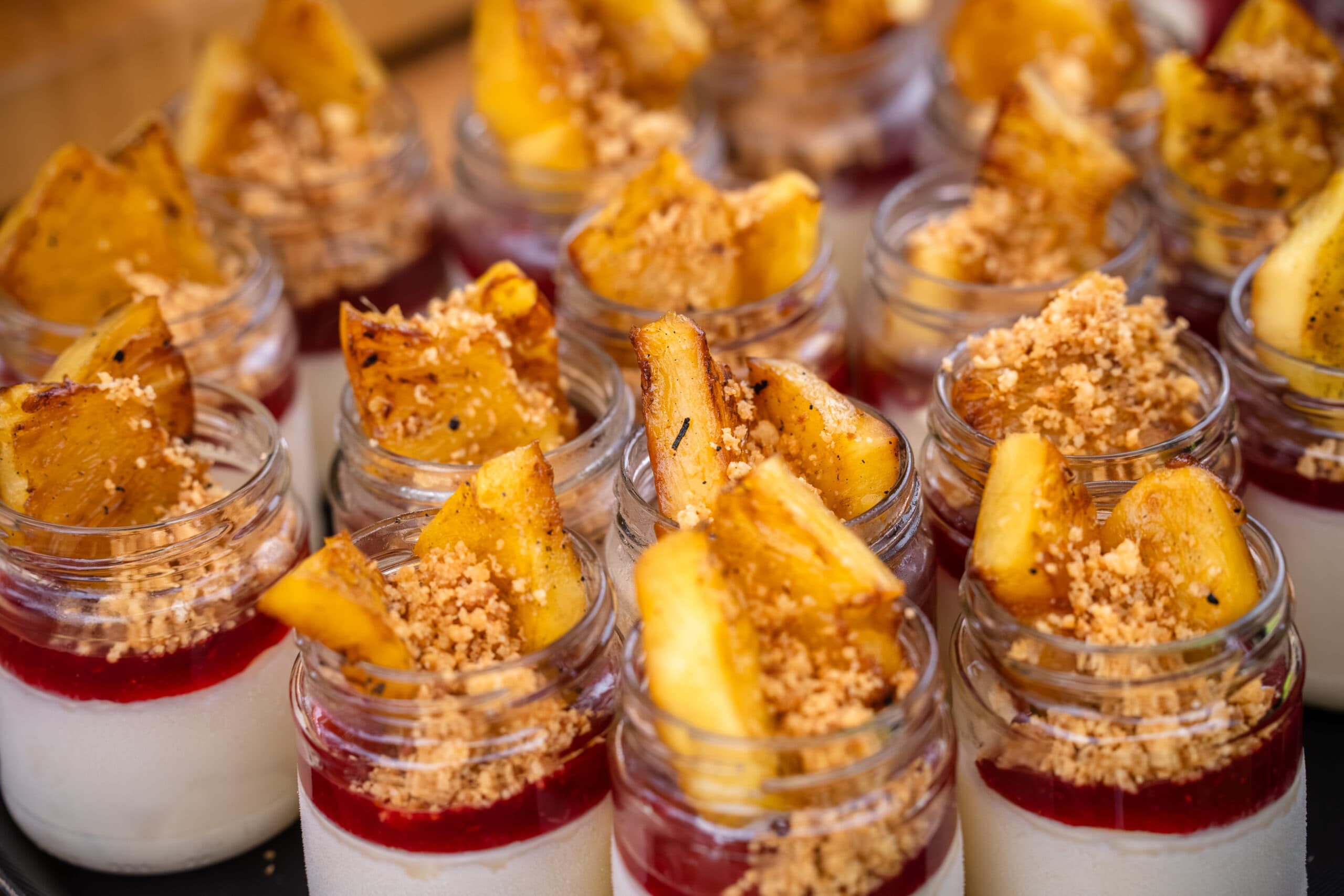 Dessertglaasjes met panna cotta, gekarameliseerde ananas en crumble