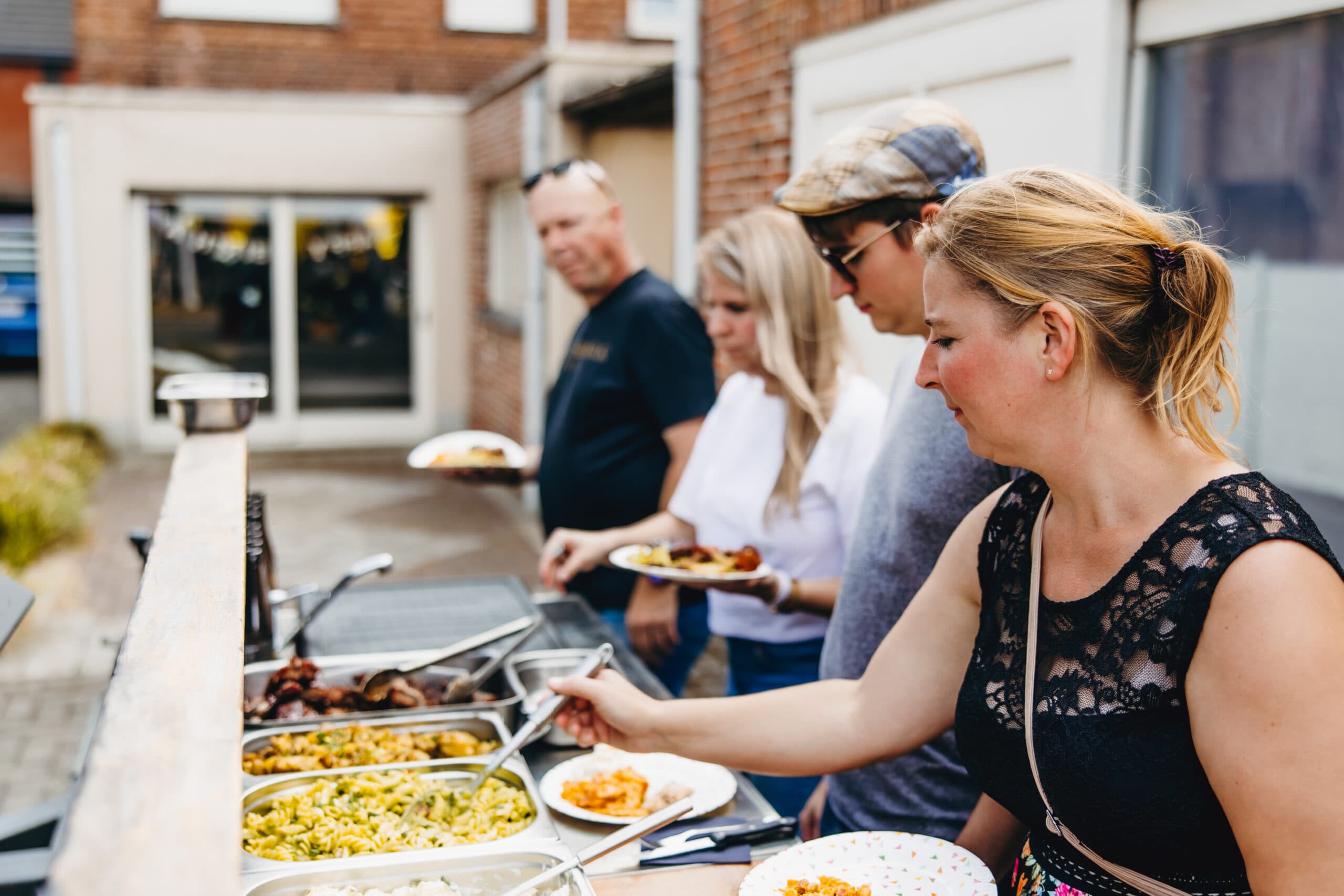 Gasten scheppen zelf op bij het buffet op een event