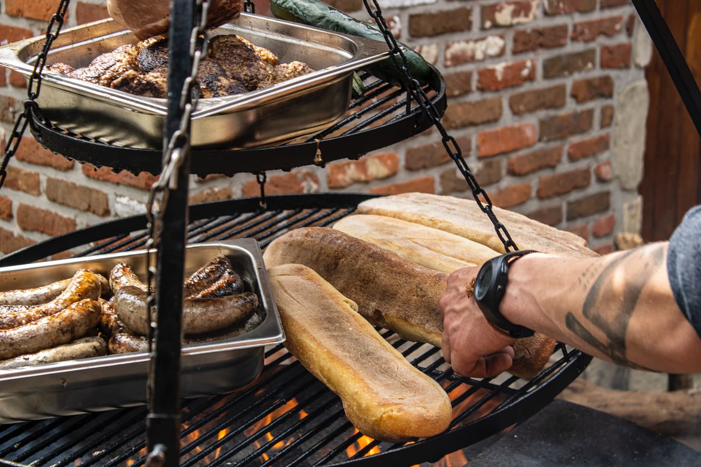 Stokbrood en vlees boven het vuur op de tripod-grill