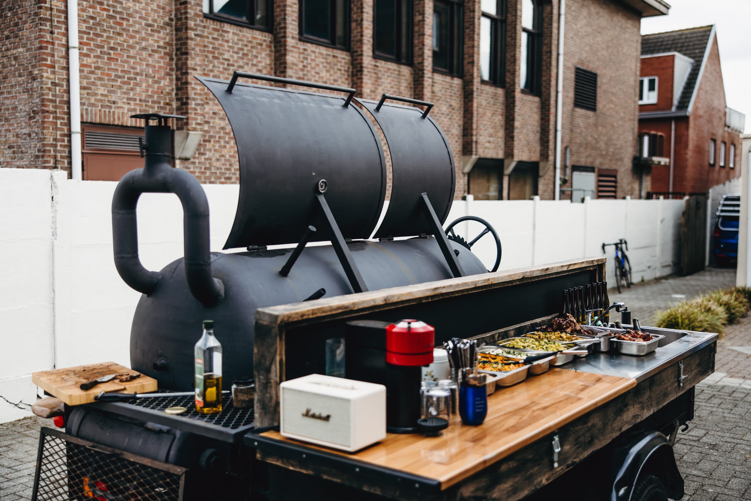 Mobiele smoker en serveerkar met gerechten klaar voor de gasten